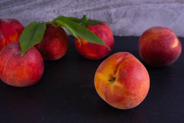 Siyah arka planda olgun şeftaliler, yakın plan.