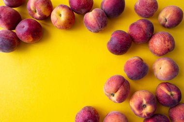 a lot of ripe peaches scattered around the edge on a yellow background