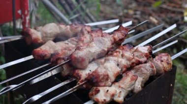 Kömürde et pişirme süreci. Adam ızgarada et pişiriyor.