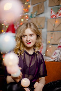 2020 numaralı kameraya bakan, Noel ışıklarıyla güzel bir bayanın yakın portresi.