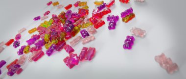 Transparent pink sweet gummy bears laying background clipart