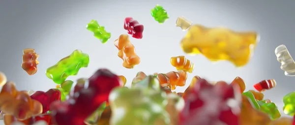 Transparante kleurrijke zoete gummy beren vallen achtergrond — Stockfoto