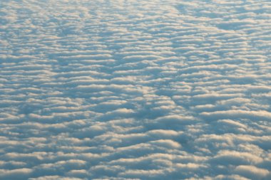 Gökyüzü ve bulutlar bir uçak penceresinden