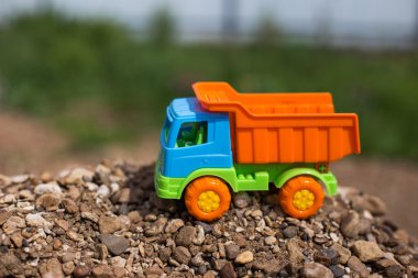 çok renkli oyuncak kamyon kum ve taşların fonunda