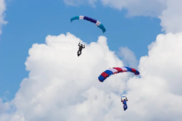 Paracadutisti tra le nuvole e cielo blu — Foto Stock