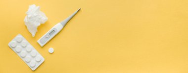 yatay afiş biçimi. İlaçlar, termometre ve haplar sarı arka planda. Test için boş yer var. Hastalık ve tedavi konsepti covid 19, koronavirüs