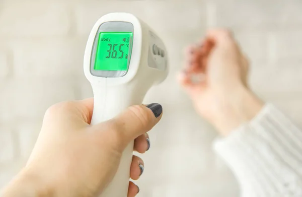 A non-contact digital infrared thermometer recorded the normal body temperature. prevention of coronavirus infection in public places during quarantine