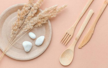 Çevre dostu kullan-at yemekler beyaz mermer arka planda kağıt üretiyor. Sarılmış kaşıklar, çatal, bıçaklar, kağıt bardaklı tabaklar. Geri dönüşüm kavramı