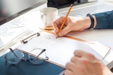 Ofiste çalışan bir iş adamı ve masasında belgeler var. Planları, belgeleri analiz et.