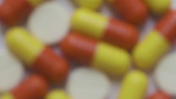 Diferentes tabletas y píldoras de colores en fondo blanco — Vídeo de stock