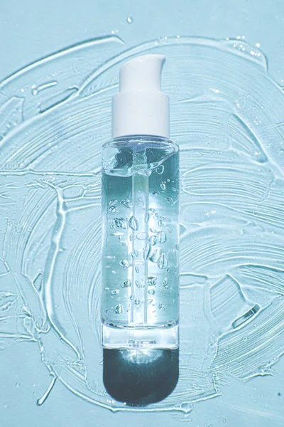 Słoik płynnego serum żelowego, tekstura mikro bańki na niebieskim tle, koncepcja piękna — Zdjęcie stockowe