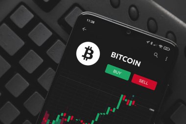 Ufa, Rusya - 16 Mayıs 2021: Ekran akıllı telefonunda Logo Bitcoin. Borsada yükselme ve düşüş hisseleri. satın alma ve satma.