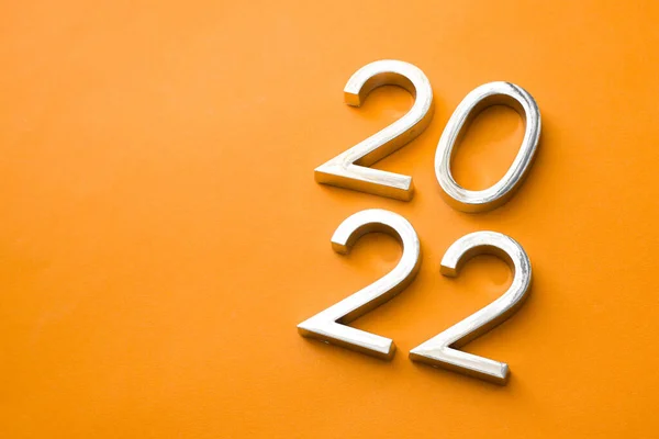 Close-up of metal numbers 2022 on orange background. change year 2021 to 2022 — Stock Photo, Image