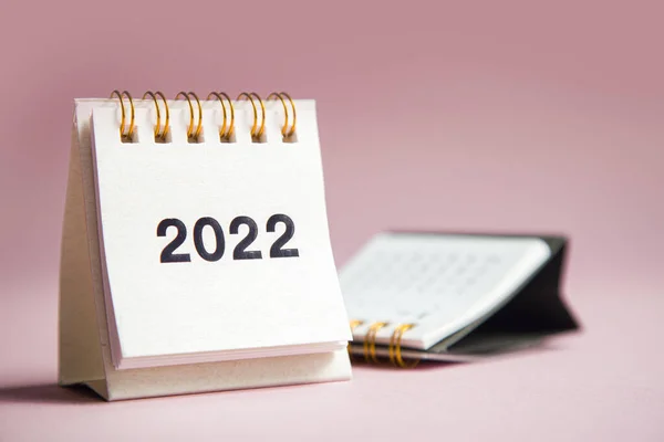 Boldog új évet 2022-ben. Zárja be a naptárat egy rózsaszín asztalon — Stock Fotó