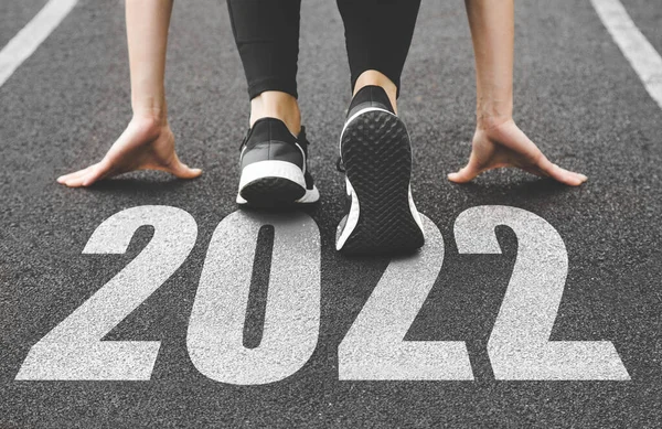 Primer plano de los pies femeninos en zapatillas de deporte al principio. Comienzo y comienzo del nuevo año 2022, metas y planes para el próximo año —  Fotos de Stock