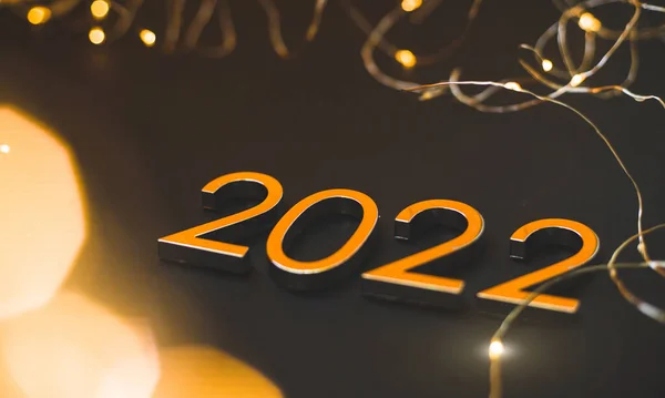 Guldnummer 2022 på svart bakgrund med gyllene bokeh — Stockfoto