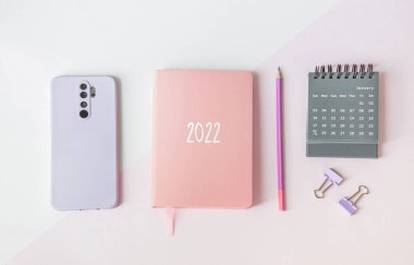 Not defteri takvimi ve akıllı telefondan ofis masasında kompozisyon. Gelecek yıl için planlar ve hedefler