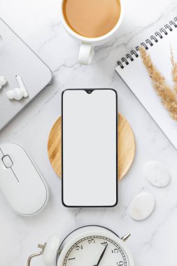 Mermer ofis masasına akıllı telefon kurgula. Minimum iş telefonu çerçevesi ve sunum için boş ekran konsepti. Düz yatış, üst görünüm