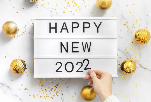 Happy new year 2022, flat lay composition on table with woman hand