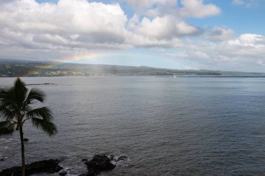 Hilo Körfezi 'nden Mauna Kea sahiline bakıyorum. Büyük Hawaii Adası açıklarındaki tropikal sularda güzel bir gökkuşağı uzanıyor..