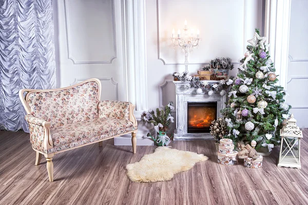 Interior de Navidad con chimenea y sofá . Imágenes De Stock Sin Royalties Gratis