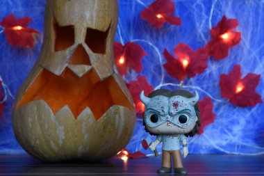 Korku filmi The Black Phone 'daki seri katil Grabber' ın aksiyon figürü. Cadılar Bayramı dekor, Jack o fener, örümcek ağı, yapraklar, ışıklar.