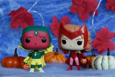Marvel süper kahramanları Kırmızı Cadı Wanda ve Vizyon 'un Cadılar Bayramı kostümlü Funko Pop aksiyon figürleri. Örümcek ağı, kırmızı yapraklar, balkabakları, mavi sis manzarası.