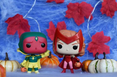 Marvel süper kahramanları Kırmızı Cadı Wanda ve Vizyon 'un Cadılar Bayramı kostümlü Funko Pop aksiyon figürleri. Örümcek ağı, kırmızı yapraklar, balkabakları, mavi sis manzarası.