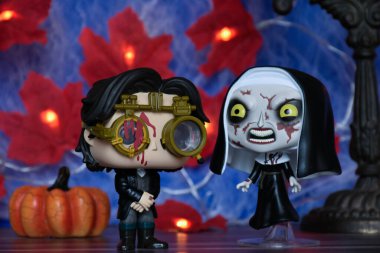 Sleepy Hollow 'dan Ichabod Crane' in Funko Pop aksiyon figürleri ve The Hojuring Fear franchise 'dan Rahibe. Cadılar Bayramı dekoru, balkabağı, kırmızı yapraklar, ışıklar.