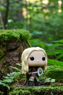Eowyn 'in Funko Pop aksiyon figürü, Rohan' ın asil kadını, Yüzüklerin Efendisi adlı fantezi filmindeki bakire. Yeşil orman, yosun, eğreltiotu yaprakları.