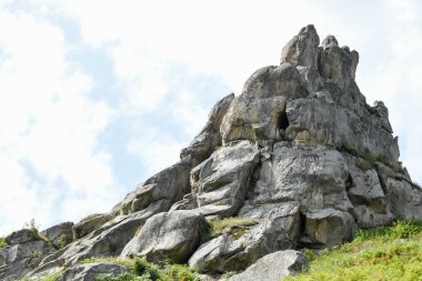 Tustan 'ın kaya kompleksi, antik şehir kalesi. Tepedeki yeşil çimenler, güneşli bir gün, mavi gökyüzü. Karpatlar 'da yaz mevsimi. Lviv oblast, Ukrayna.