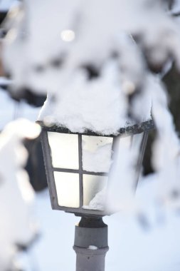 Kalın kabarık kar tabakasıyla kaplı klasik sokak lambası. Kış bahçesinin estetik detayları.