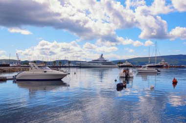  Güzel Akdeniz manzarası sonbahar günü. Karadağ, Tivat şehri. Kotor Körfezi ve Porto Karadağ marinası manzarası. Bulutlar, yatlar ve balıkçı tekneleri suya yansıyor