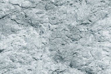 Açık gri kayanın taştan arka planı, dik kayalığın dokusu.