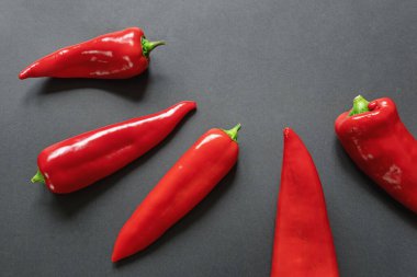 Siyah arka planda parlak kırmızı tatlı biberler. Düz konum, metin için boşluk