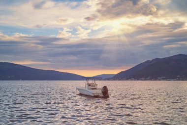 Güzel Akdeniz manzarası ve gün batımında teknesi suda. Karadağ, Adriyatik Denizi. Tivat kenti yakınlarındaki Kotor Körfezi manzarası