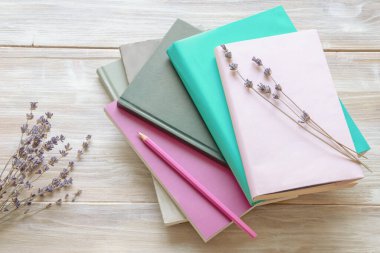 Kırsal masada yığınla kitap ve kurutulmuş lavanta çiçeği. Uzayı kopyala Renk tonu