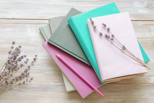 Kırsal masada yığınla kitap ve kurutulmuş lavanta çiçeği. Uzayı kopyala Renk tonu