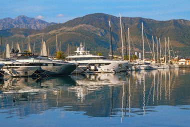 Montenegro, Adriatic Sea. View of Porto Montenegro marina in   Tivat city. Yachts and sailboats are reflected in water of Bay of Kotor