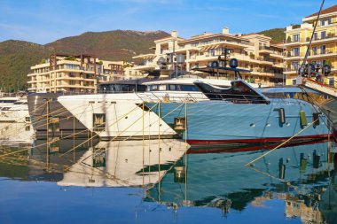 Tivat, Montenegro - November 12, 2025:  View of Porto Montenegro marina in Tivat city on sunny autumn day. Different yachts and buildings are reflected in water of Bay of Kotor, Montenegro