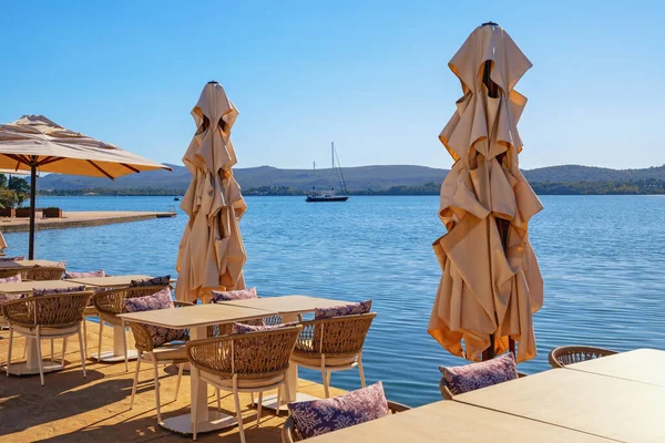 Güneşli bir sonbahar Akdeniz manzarası. Karadağ, Adriyatik Denizi, Kotor Körfezi. Tivat şehrinin setinde küçük bir kafe.