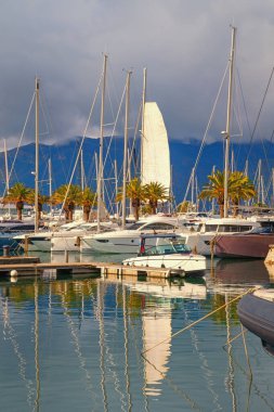 Karadağ, Tivat kentindeki Porto Montenegro marinası manzarası. Bulutlu bir kış günü. Yatlar ve yelkenliler Kotor Körfezi 'nin suyuna yansıyor.