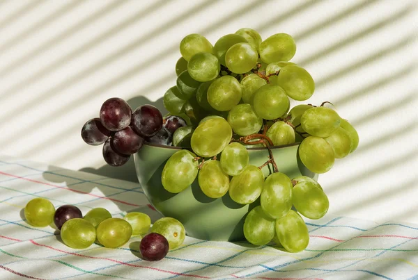 Son racimos de uvas. Sol a través de la ventana con persianas —  Fotos de Stock