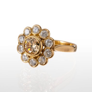 18 kt 'lık sarı altın yüzük ve etrafında 10 parlak kesimli elmas var. Beyaz bir arka planda yansıması ile fotoğraflanmış..