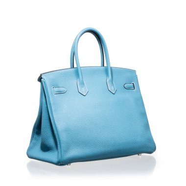 Modern mavi deri çanta, beyaz arka planda yansıması ile fotoğraflanmış.