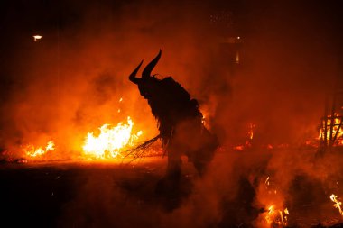 Krampus alevlerin ortasında, dinsel folklor figürüne eşlik eden şeytani bir varlık var. Bu gelenek Hıristiyan mitolojisine bağlıdır..