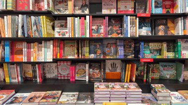 Kütüphane rafında sergilenen çeşitli kitaplar. Udine, İtalya. 18 Ocak 2026
