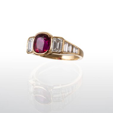 Yakut ve 2 elmasla birlikte 18 kt sarı altın yüzük, beyaz bir arka planda fotoğraflandı.
