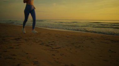 Sahilde yoga yapan genç bir kadın.