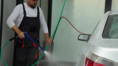 Araba yıkayan bir adam.